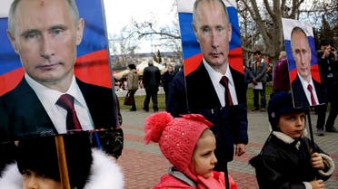 Children hold portraits of Russia's President Vladimir Putin as they take part in a rally to mark Defender of the Fatherland Day in the Crimean city of Sevastopol, on February 23, 2016.
