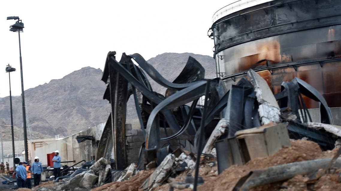 Saudi and foreign workers talk next to a burnt tank at a power station on August 27, 2016 in the Saudi border city of Najran, a day after it was struck by a rocket fired from Yemen. The attack on the transformer in Najran, which lies just across the Yemen border, marks a rare hit on Saudi Arabia's infrastructure after months of periodic bombardment of the area. Cross-border attacks into Saudi Arabia have intensified since the suspension in early August of UN-brokered peace talks between the Shiite Huthi rebels and their allies, and Yemen's internationally-recognised government which has the military support of a Saudi-led Arab coalition. FAYEZ NURELDINE / AFP