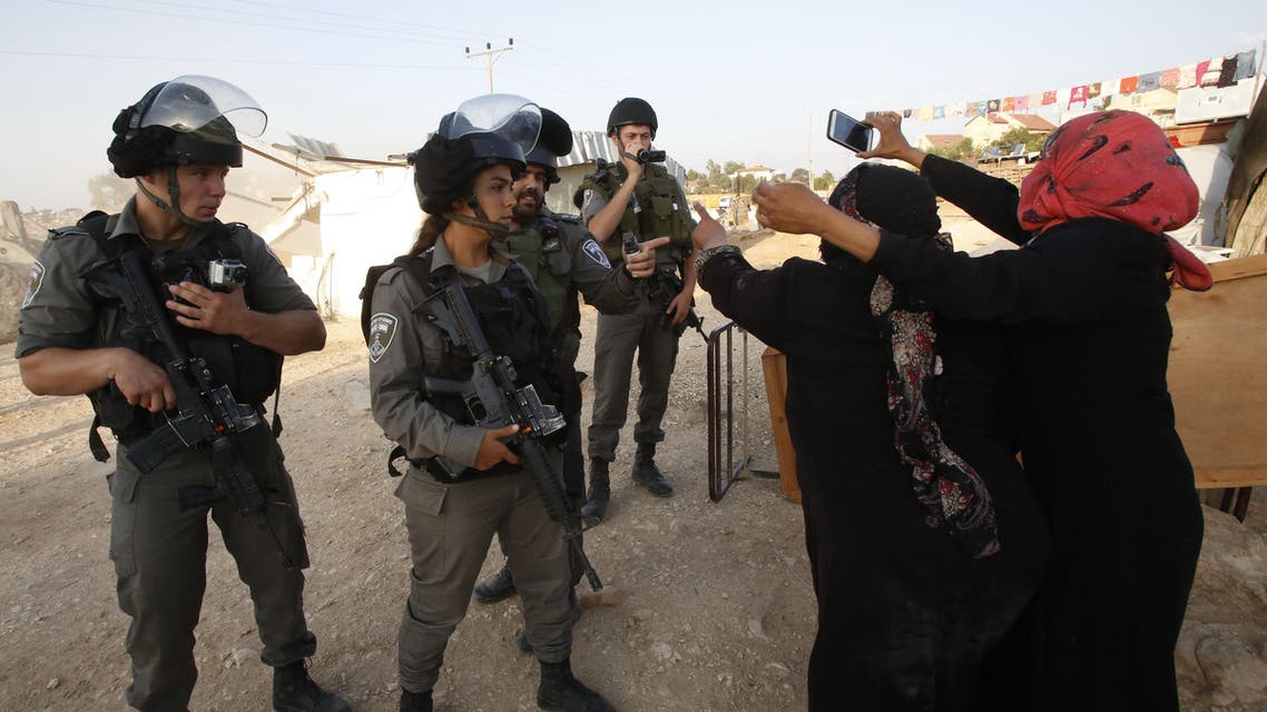 Palestinian women react in front of Israeli border police as Israeli bulldozers destroy their homes and a community centre in the southern West Bank village of Umm al-Kheir, near the Israeli settlement of Karmel, on August 24, 2016, after Israeli authorities said they were built without permission. AFP