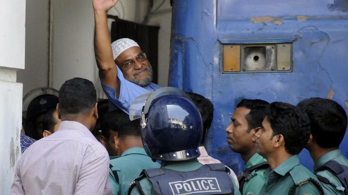 Bangladeshi Jamaat-e-Islami party leader, Mir Quasem Ali waves as he enters a van at the International Crimes Tribunal court in Dhaka. (AFP)