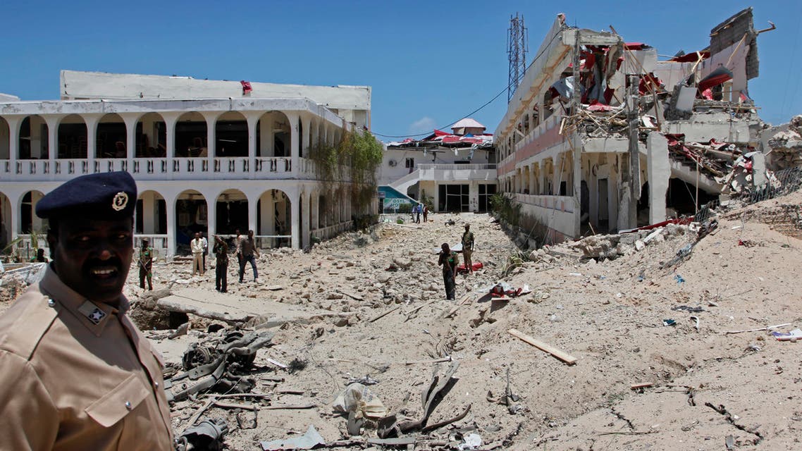 Somali soldiers stand near to a building destroyed by a blast near the presidential palace in the capital Mogadishu, Somalia Tuesday, Aug. 30, 2016. A suicide bomber has detonated an explosives-laden truck near the gate of Somalia's presidential palace in the capital on Tuesday, killing at least five people, police say. (AP Photo/Farah Abdi Warsameh)