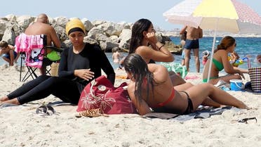  In this image taken from video, Nesrine Kenza who says she is happy to be free to wear a burkini, and two unidentified friends rest on the beach in Marseille, France, Monday Aug. 29, 2016. A high court struck down the previous ban of the wearing of so called burkini Friday, but the debate revealed raw tensions between the secular establishment and sectors of France's estimated 5 million Muslims. (AP Photo)