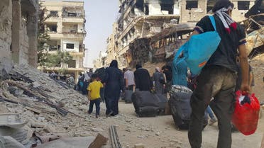  This photo provided by the Syrian anti-government activist group Local Council of Daraya City, which has been authenticated based on its contents and other AP reporting, shows Syrian citizens carry their belonging as they prepare to evacuate from Daraya, a blockaded Damascus suburb, on Friday, Aug. 26, 2016. The development in the Daraya suburb is part of an agreement struck between the rebels and the government of President Bashar Assad. Rebels agreed to evacuate after four years of grueling bombardment and a crippling siege that has left the sprawling suburb southwest of the capital in ruins.(Local Council of Daraya City via AP)