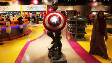 An Emirati woman walks past a statue of Captain America at the IMG Worlds of Adventure amusement park in Dubai, United Arab Emirates, on Wednesday, Aug. 31, 2016. The IMG Worlds of Adventure indoor theme park opened Wednesday in Dubai, hoping to draw thrill seekers to its air-conditioned confines. (AP Photo/Jon Gambrell)