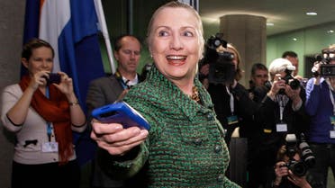 In this Dec. 8, 2011, file-pool photo, then-Secretary of State Hillary Rodham Clinton hands off her mobile phone after arriving for a meeting in The Hague, Netherlands. (AP)