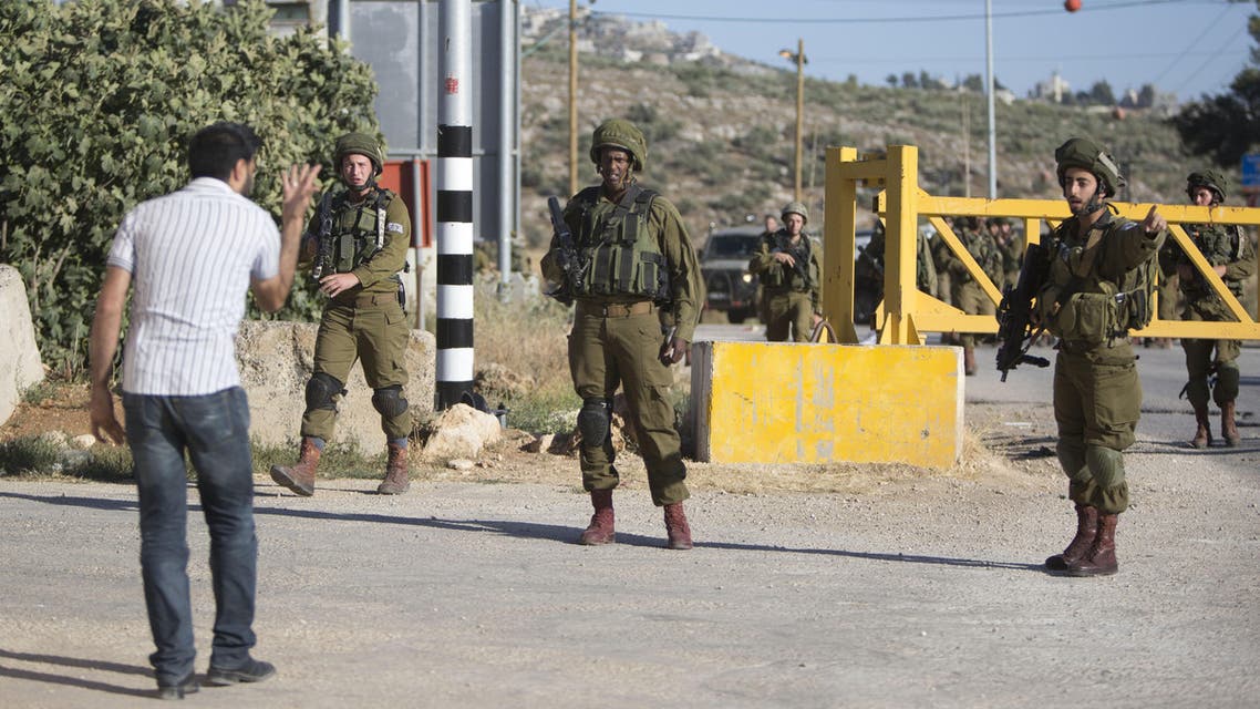Israeli soldiers argue with a Palestinian at a checkpoint near the West Bank city of Nablus, Friday, June 10, 2016, after a Palestinian attempted a stabbing attack. Palestinian was shot and wounded, army said. (AP)