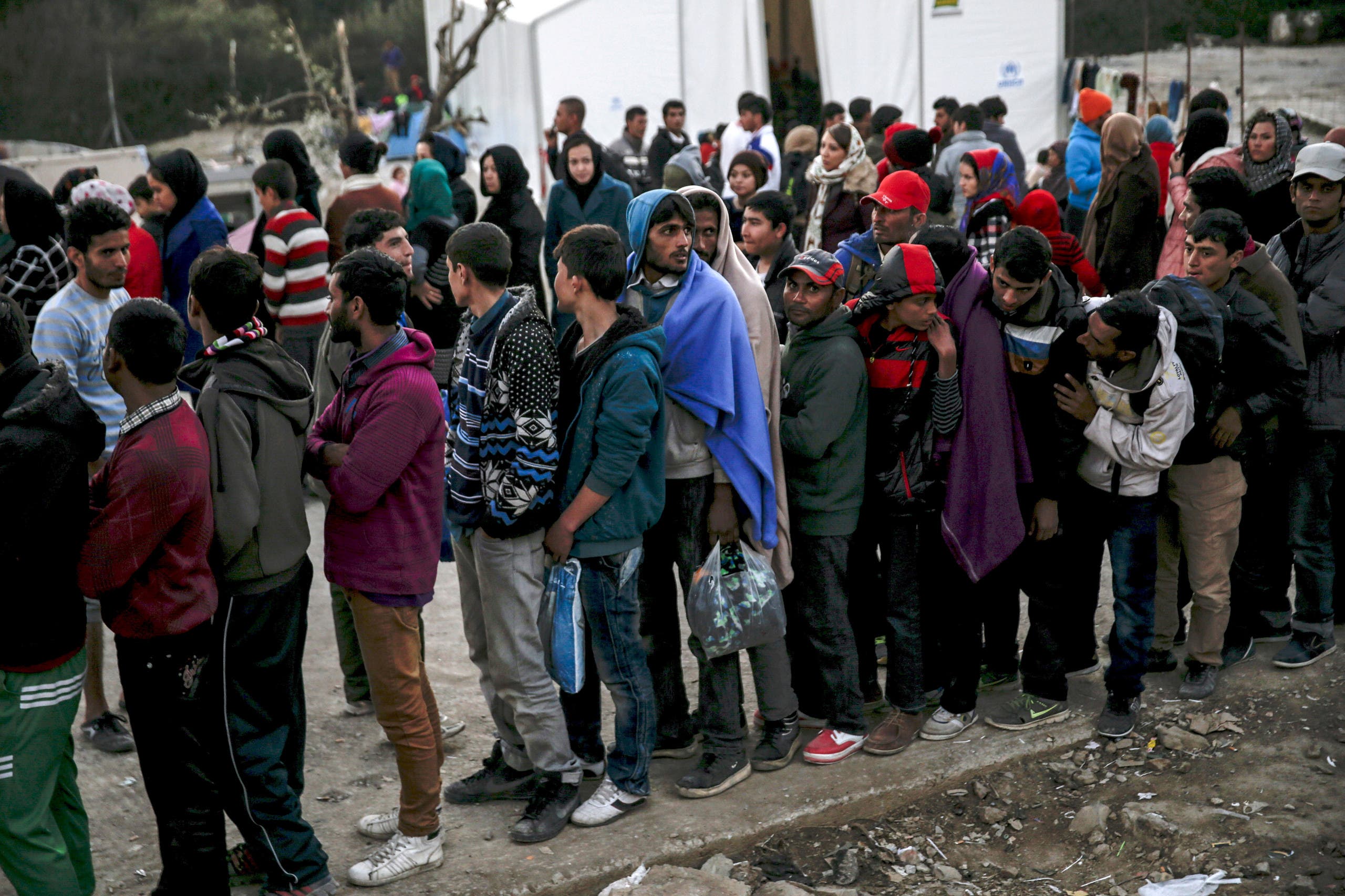 Refugees and migrants line up for a food distribution at the Moria refugee camp on the Greek island of Lesbos, November 5, 2015. REUTERS