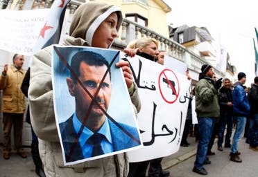 A Syrian immigrant holds a poster of Syrian President Bashar al-Assad during a protest against his regime in front of the Syrian embassy in Belgrade December 23, 2011. (File photo: Reuters)