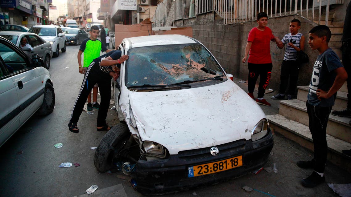 In this Monday Sept. 5, 2016 photo, Palestinian look at the car in which the driver was wounded and passenger killed by Israeli border police in Shuafat refugee camp in Jerusalem. ap