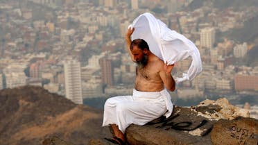 A Muslim pilgrim adjusts his ihram clothing on the top of Mount Al-Noor ahead of the annual Hajj pilgrimage. (Reuters)