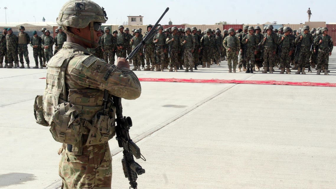In this Sunday, July 24, 2016 photo, a US military personal stands guard during a graduation ceremony in Lashkargah, capital of southern Helmand province, Afghanistan. (AP)