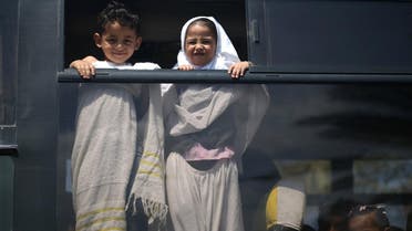 Palestinian children arrive by bus to take part in an exercise teaching them Hajj rituals during a school activity in Gaza City. (AFP)