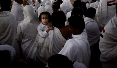 An Indonesian father carries his daughter through the crowd after reaching the top of a rocky hill known as Mountain of Mercy, on the Plain of Arafat, during the annual hajj pilgrimage, ahead of sunrise near the holy city of Mecca, Saudi Arabia, Sunday, Sept. 11, 2016. Mount Arafat, marked by a white pillar, is where Islam's Prophet Muhammad is believed to have delivered his last sermon to tens of thousands of followers some 1,400 years ago, calling on Muslims to unite. (AP)