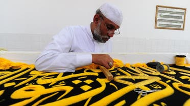 A Saudi worker sews Islamic calligraphy in gold thread on a drape to cover the Kaaba at the Kiswa factory in the holy city of Makkah. (AFP)