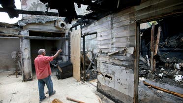 Farhad Khan, who has attended the Islamic Center of Fort Pierce for more than seven years, shows members of the media its charred remains, Thursday, Sept. 15, 2016, in Fort Pierce, Fla. AP