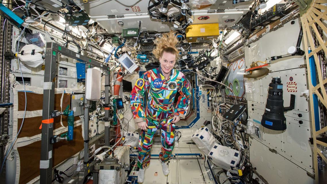 NASA astronaut Kate Rubins aboard the International Space Station wearing a hand-painted spacesuit decorated by childhood cancer patients at the University of Texas MD Anderson Cancer Center in Houston. NASA said Rubins will chat from the space station with patients during a 20-minute call on Friday, Sept. 16, 2016. (NASA via AP)