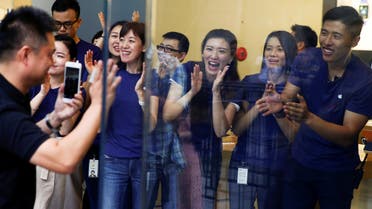Staff members applaud a customer as he arrives to purchase Apple’s new iPhone 7 at an Apple store in Beijing, China, September 16, 2016. (Reuters)
