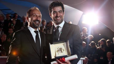 Actor Shahab Hosseini (right) and director director Asghar Farhadi pose for photographers after Hosseini won the Best Actor award and Farhadi, the Best Screenplay award for the film Forushande (The Salesman), at the awards ceremony at the 69th international film festival, Cannes, southern France, on May 22, 2016. (AP)