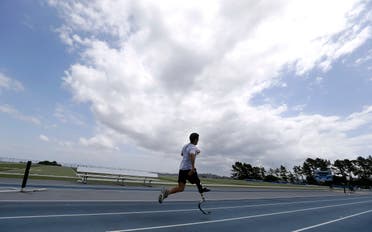 In this May 7, 2013, photo, Mohamed Lahna, a 2016 Paralympic hopeful in the triathlon, poses for a photograph on the College of San Mateo track in San Mateo, Calif. AP