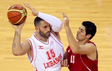 Lebanon's Fadi El Khatib (white) fights for the ball with Tunisia's Bechir Hedidane during the men's basketball game at the Arab Games 2011 in Doha December 10, 2011. REUTERS