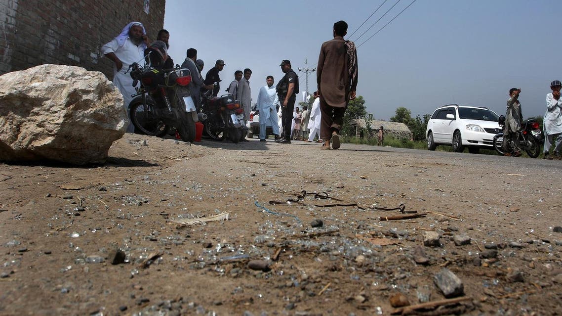 Pakistani police officers and local residents gather at the site of firing incident at Garhi Sohbat Khan on the outskirts of Peshawar, Pakistan, Sunday, Sept. 18, 2016. Two gunmen on a motorcycle killed three soldiers Sunday, police said. (AP Photo/Mohammad Sajjad)