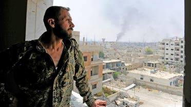 A Syrian army soldier looks out from a window as smoke rises from the besieged Damascus suburb of Daraya. (File photo: Reuters)