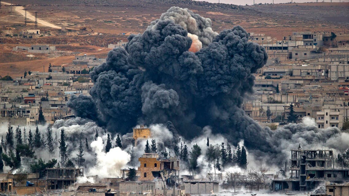 FILE -- In this Nov. 17, 2014 file photo, smoke rises from the Syrian city of Kobani, following an airstrike by the US led coalition, seen from a hilltop outside Suruc, on the Turkey-Syria border. After months of losing ground in Iraq and Syria, the Islamic State group is showing signs of the wear and tear, with commanders on the ground saying they are seeing an increase in desertions. But the jihadis appear to be lashing back with more terrorist and chemical attacks. (AP Photo/Vadim Ghirda, File)