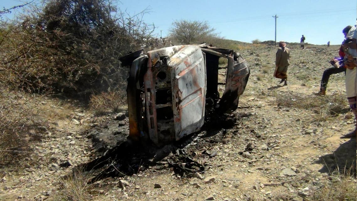 People gather near a destroyed car that was carrying militants in the Sawmaa area of al-Bayda province, Yemen, Saturday, April 19, 2014. AP