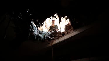 A soldier looks through a hole in a building damaged after an airstrike by Saudi-led coalition in Sanaa, Yemen. (File photo: AP)