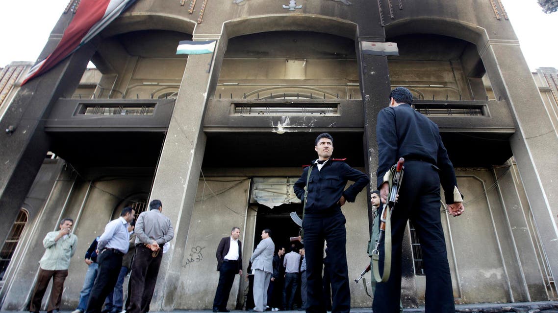 In this Monday March 21, 2011 file photo, Syrian policemen stand in front of a court building that was set on fire by Syrian anti-government protesters, in the southern city of Daraa, Syria. ap