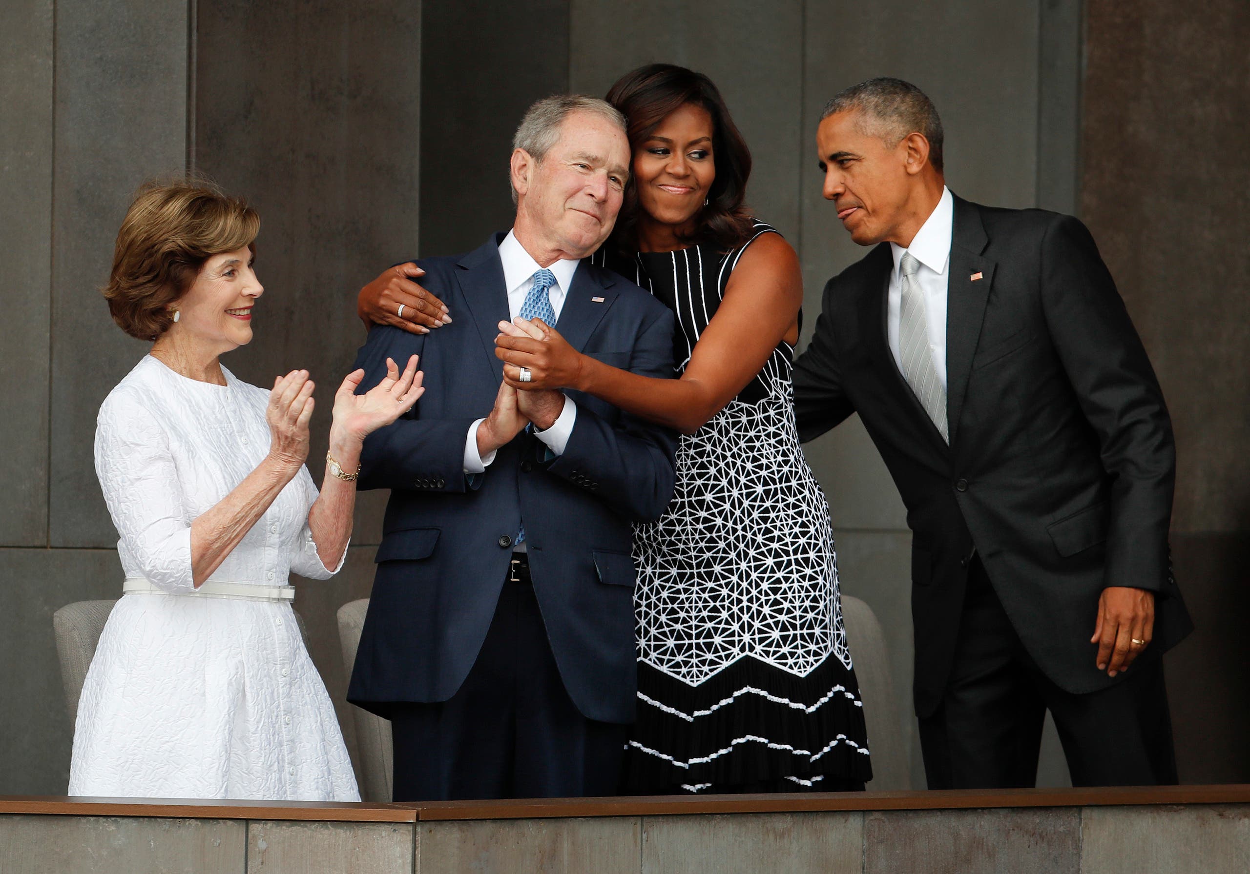 First lady Michelle Obama, center, hugs former President George W. Bush, as President Barack Obama and former first lady Laura Bush walk on stage at the dedication ceremony of the Smithsonian Museum of African American History and Culture on the National Mall in Washington, Saturday, Sept. 24, 2016. (AP)