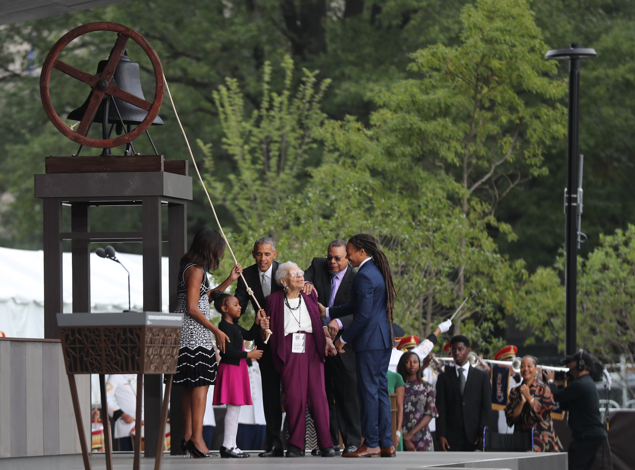President Barack Obama, with first lady Michelle Obama and Ruth Odom Bonner, center, rings the bell opening the Smithsonian National Museum of African American History and Culture on the National Mall in Washington, Saturday, Sept. 24, 2016. (AP)