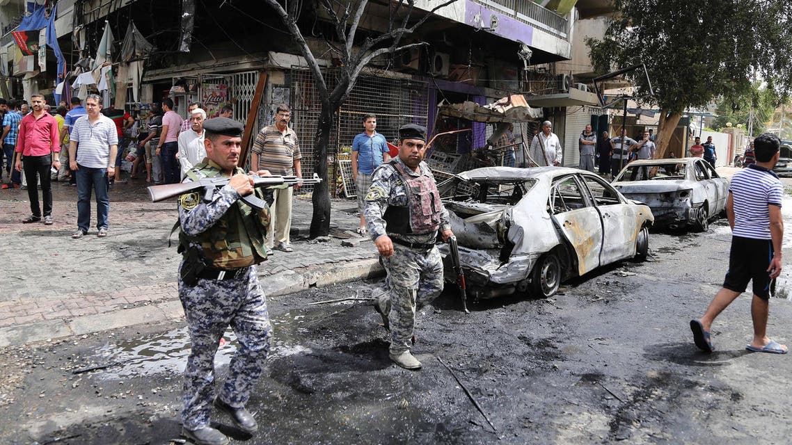 People and security forces gather at the site of a car bomb explosion at a convenience store in the Karrada neighborhood of Baghdad, Iraq, Friday, April 10, 2015. Iraqi officials say the blast in the downtown district killed several people and wounded a dozen. (AP)