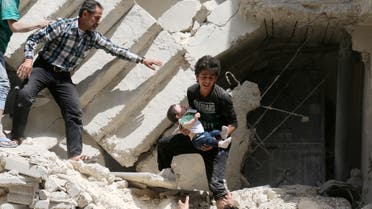 Syrians evacuate a toddler from a destroyed building following a reported air strike on the rebel-held neighbourhood of al-Kalasa in the northern Syrian city of Aleppo, on April 28, 2016.  afp