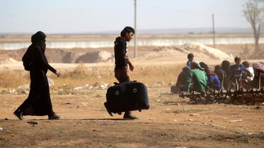 Civilians, who fled from ISIS-controlled areas, gather at a checkpoint controlled by rebel fighters in the northern Syrian rebel-held town of al-Rai, in Aleppo. (Reuters)