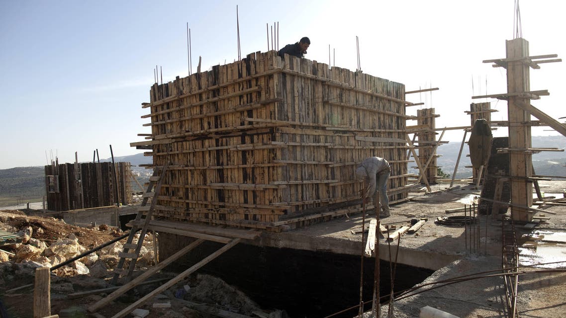 This file photo taken on February 22, 2012 shows Palestinian workers constructing new houses in the Jewish settlement of Shilo in the West Bank. Israel has approved on October 1, 2016. (File photo: AFP)