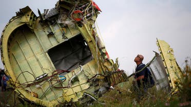 A Malaysian air crash investigator inspects the crash site of Malaysia Airlines Flight MH17, near the village of Hrabove (Grabovo) in Donetsk region, Ukraine, July 22, 2014. REUTERS/Maxim Zmeyev/File Photo