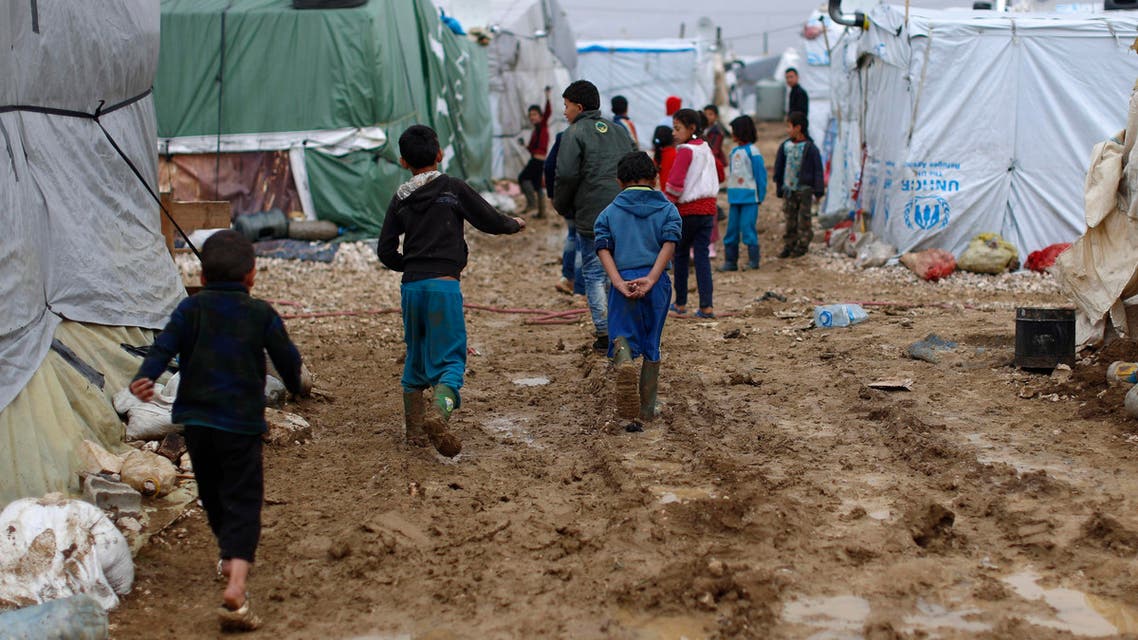 In this Monday, Jan. 4, 2016 file photo, Syrian refugee children walk in mud after a heavy rain at a refugee camp in the town of Hosh Hareem, Bekaa valley, east Lebanon. In a report published Tuesday, Jan. 12, 2016, the New York-based rights group Human Rights Watch said Lebanese residency laws are putting Syrian refugees in danger. The regulations, adopted a year ago, have forced refugees to either return to Syria, where they are at risk of persecution, torture or death, or to stay in Lebanon illegally, leaving them vulnerable to exploitation and abuse. (AP)