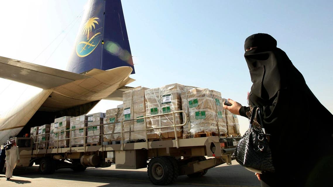 A woman walks by as emergency aid and goods are loaded onto a cargo plane bound for Gaza. (Reuters)