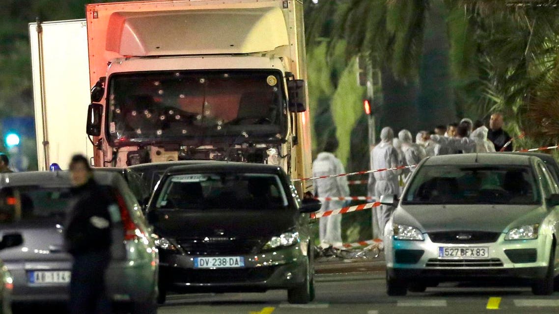 Forensic officers stand near a truck with its windscreen riddled with bullets, that plowed through a crowd of revelers who'd gathered to watch the fireworks in the French resort city of Nice, southern France, Friday, July 15, 2016. At least 80 people were killed before police killed the driver, authorities said. (AP Photo/Claude Paris)