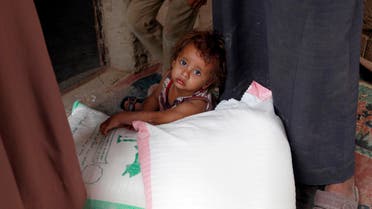 A Yemeni young child sits next to food rations that a local charity is distributing to families affected by the country's ongoing conflict during the fasting month of Ramadan on June 15, 2016 in an empoverished part of the capital Sanaa. Yemen's warring parties are struggling to seal a peace deal as mutual mistrust has overshadowed eight weeks of UN-brokered talks in Kuwait that have failed to achieve any major breakthrough. AFP