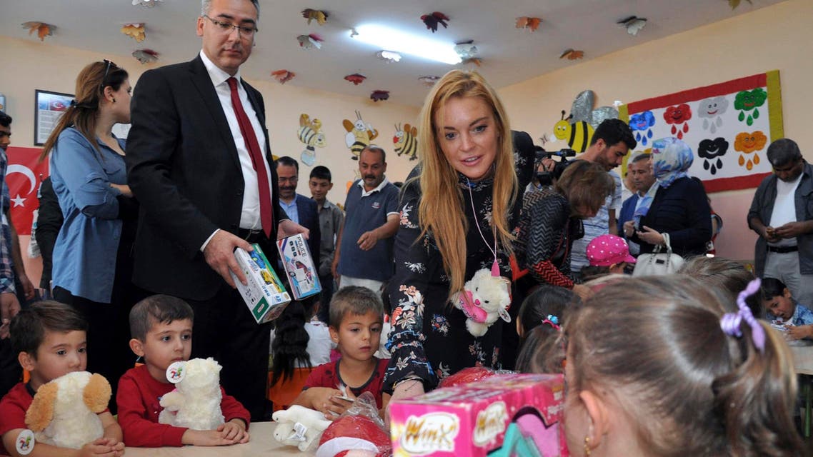 U.S. actress Lindsay Lohan gives presents to Syrian refugee children as she visits a Turkish government-run Syrian refugee camp in Nizip near Turkey's border with Syria, Saturday, Oct. 8, 2016. AP