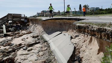 Officials photograph sections of highway A1A that were washed out by Hurricane Matthew, Saturday, Oct. 8, 2016, in Flagler Beach, Fla. The damage from Matthew caused beach erosion, washed out some roads and knocked out power for more than 1 million customers in several coastal counties. (AP Photo/Eric Gay)