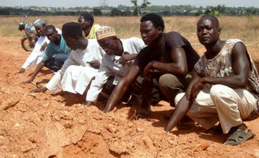 members of the Islamic Movement of Nigeria (IMN), a Shiite group, praying at a mass grave in the outskirts of northern Nigerian city of Kaduna. (AFP)