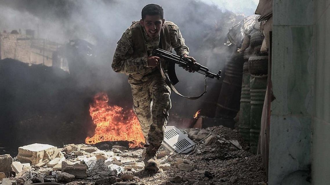 A fighter from the Jaish al-Islam (Islam Army) runs to avoid sniper fire, in the village of Tal al-Siwan area of the rebel-held stronghold of Douma. (AFP)