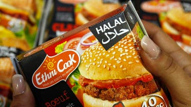 A visitor displays a Halal hamburger at the Halal show which presents food products for Muslim clients which are prepared following Islamic dietary laws, in Paris. (Reuters)