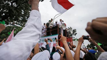 Muslim protesters raise their fists as the leader of Islamic Defenders Front, Rizieq Shihab, center, delivers his speech during a protest against Jakarta's ethic Chinese and Christian Governor Basuki Tjahaja Purnama, popularly known as Ahok, outside the City Hall in Jakarta, Indonesia, on Friday, Oct. 14, 2016. AP