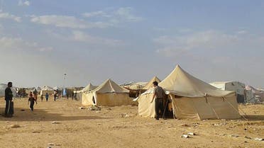 In this Wednesday, June 22, 2016 file photo, Syrians walk through the Ruqban refugee camp in Jordan's northeast border with Syria. An official says Jordan will permit regular aid drops by crane to Syrian refugees stranded on its sealed border. The comments by government spokesman Mohammed Momani signaled an apparent shift in Jordan’s position in talks with international aid agencies over access to the displaced. (AP Photo/Abu Adel, File)