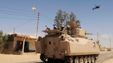 In this May 12, 2013 file photo, Egyptian Army soldiers patrol in an armored vehicle backed by a helicopter gunship during a sweep through villages in Sheikh Zuweyid, north Sinai, Egypt. (AP)