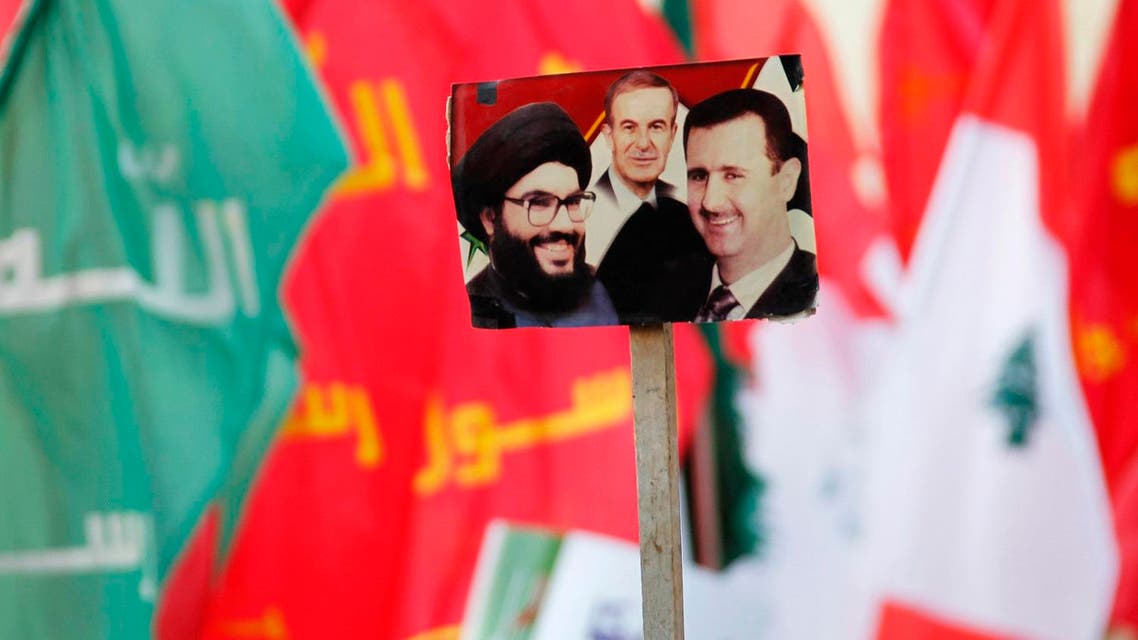 Supporters of Lebanon's Hezbollah leader Sayyed Hassan Nasrallah wave flags and a picture depicting (L-R) Lebanon's Hezbollah leader Sayyed Hassan Nasrallah, Syria's late President Hafez al-Assad, father of current President Bashar al-Assad. (Reuters)